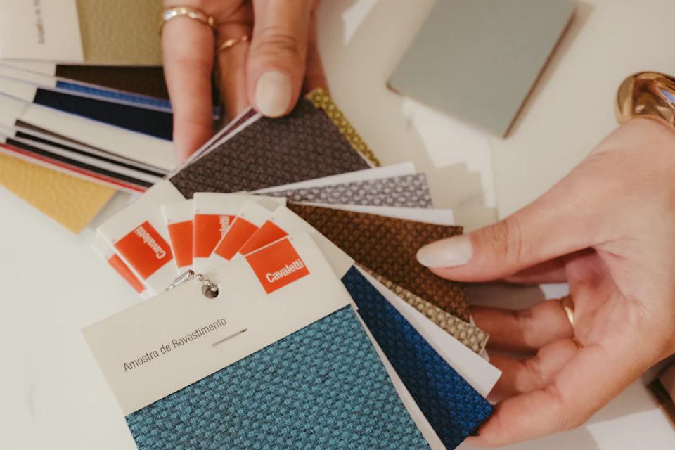 Manos eligiendo muestras de tela de colores para un proyecto de decoración